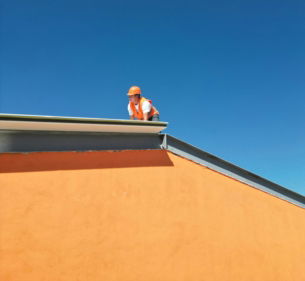 a-man-standing-on-top-of-a-roof.jpg A man standing on top of a roof