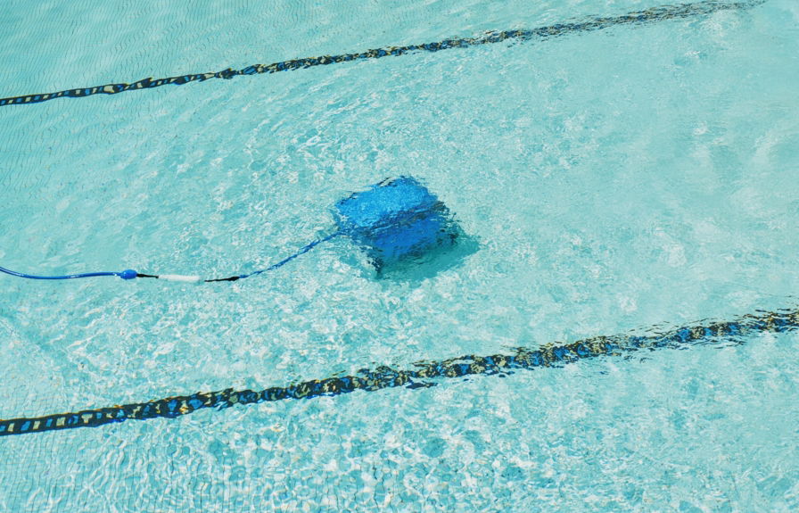 a-robotic-pool-cleaner-is-working-underwater-.jpg A robotic pool cleaner is working underwater.